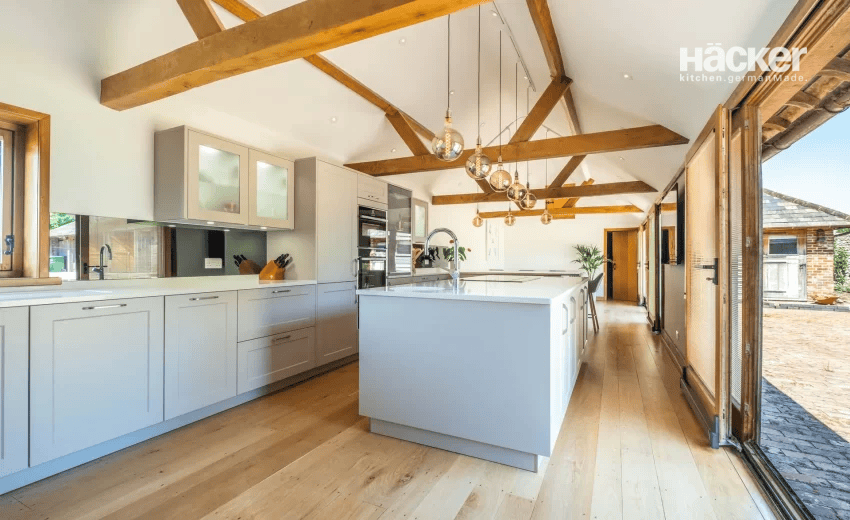 Contemporary red and grey kitchen island with dramatic marble worktop in a converted Lewes property