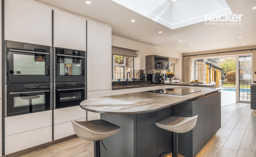 Modern grey kitchen in Angmering with white quartz worktops and glass roof lantern, by Colliers Kitchens West Sussex