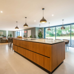 Modern open-plan kitchen island with wood effect cabinets and breakfast bar