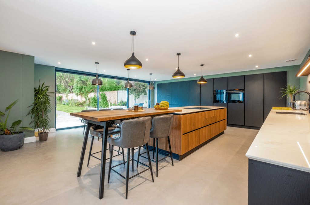 Modern open-plan kitchen with dark cabinets and wood effect island with breakfast bar