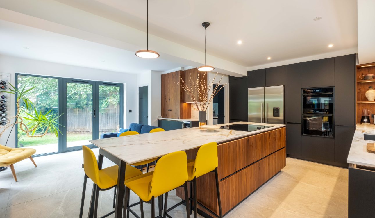 Walnut and matte black modern kitchen with island and yellow stools