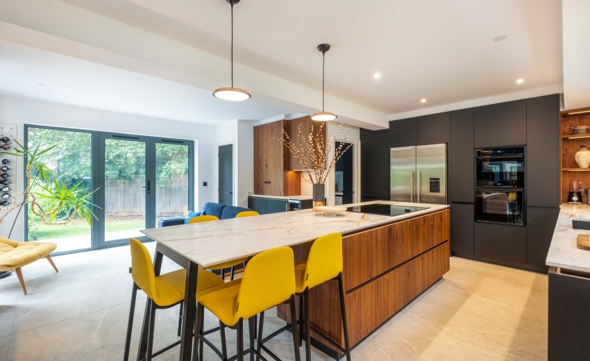 Walnut and matte black modern kitchen with island and yellow stools