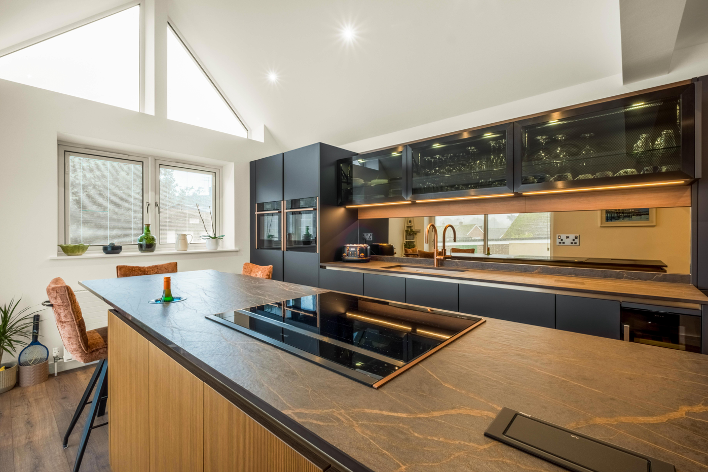 Blue and bronze modern kitchen with island and hob