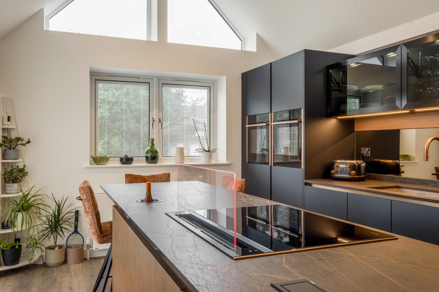 Blue and bronze modern kitchen with island and hob