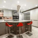 Modern kitchen with curved breakfast bar, handleless cabinets, large fridge and bright red stools