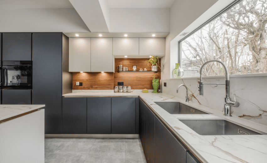 blanco sink with quooker boiling water tap and dekton reverie worktops and blue and grey cabinets with walnut wall panels