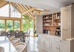 Bespoke shaker kitchen with breakfast cupboard doors open with view to garden