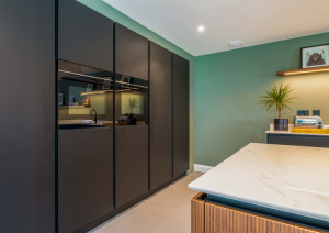 Modern open-plan kitchen dark wall units with built-in ovens