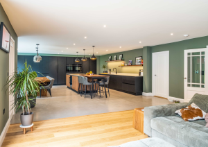Modern open-plan kitchen with dark cabinets and wood effect island with breakfast bar