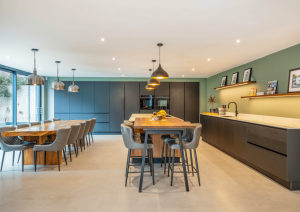 Modern open-plan kitchen with dark cabinets and wood effect island with breakfast bar