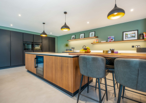 Modern open-plan kitchen island with wood effect cabinets, hob and built-in wine fridge