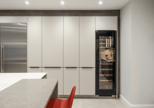 Bank of modern handleless tall cupboards with tall wine fridge