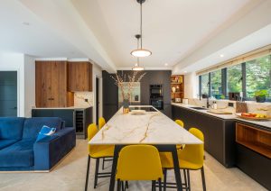 Walnut and matte black modern kitchen with island and yellow stools