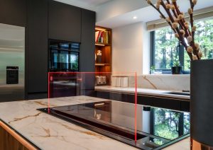 Walnut and matte black modern kitchen with island and Siemens draft air extractor hob