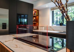 Walnut and matte black modern kitchen with island and Siemens draft air extractor hob