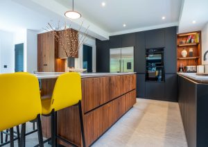 Walnut and matte black modern kitchen with island and yellow stools