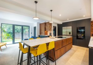 Walnut and matte black modern kitchen with island and yellow stools