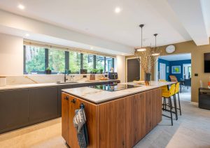 Walnut and matte black modern kitchen with island and yellow stools